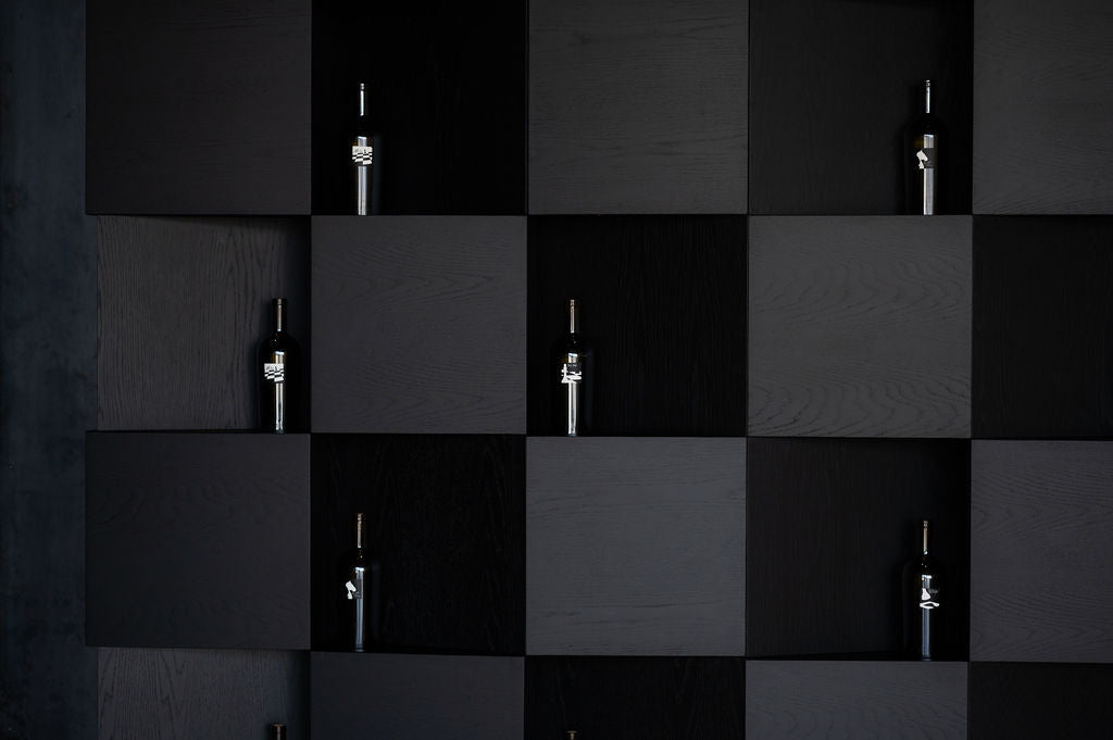 Black and gray checkered pattern with small metallic objects on a dark background