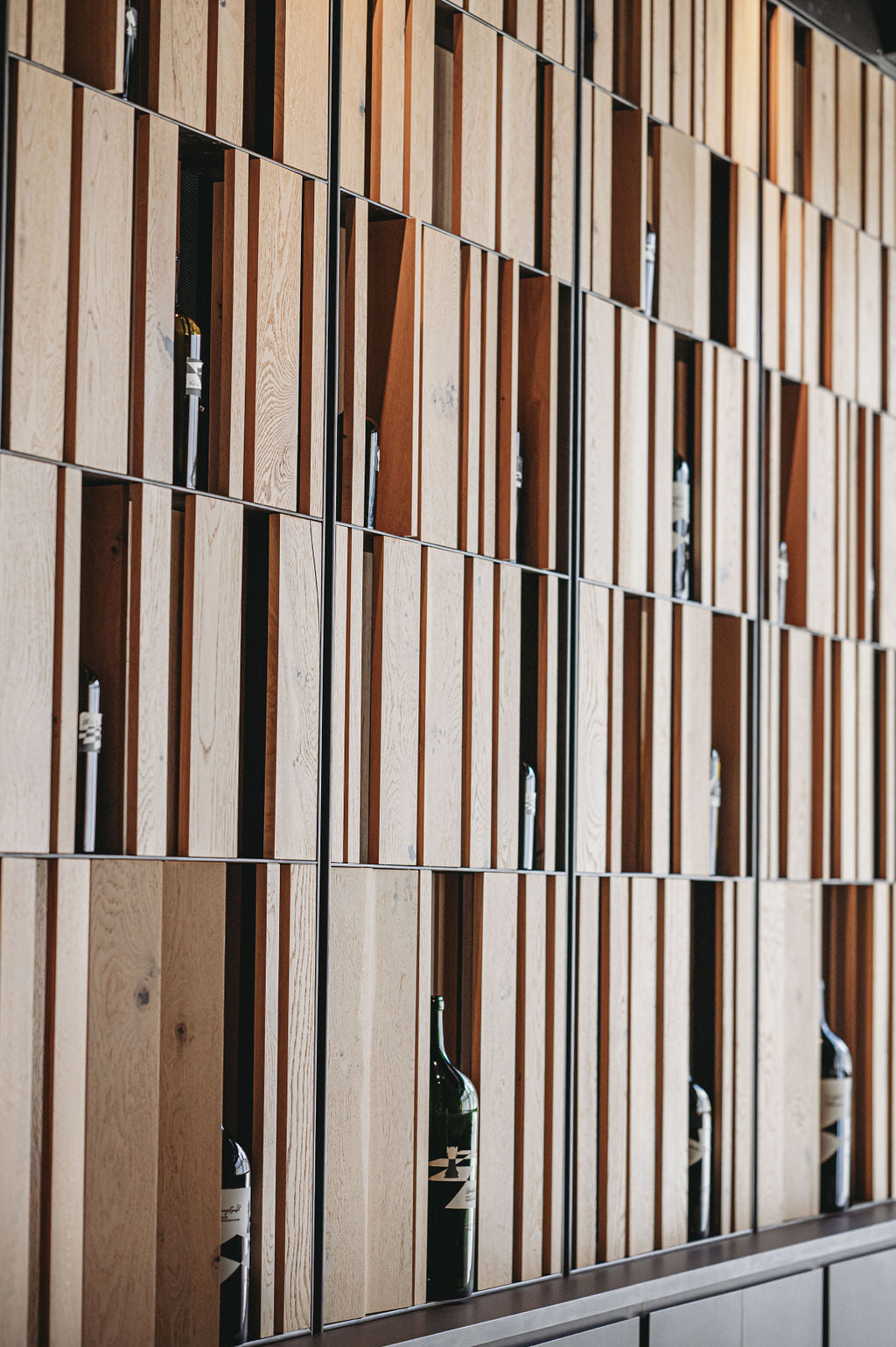 Wooden panel wall with vertical slats. BWP Spaces bespoke furniture and millwork at Checkmate Winery, BC