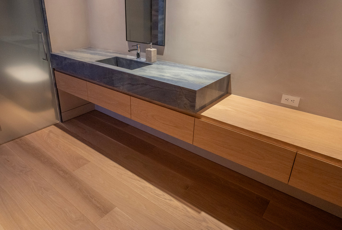 Bathroom vanity with wooden cabinets and a stone countertop. BWP Spaces custom millwork in Kelowna, BC