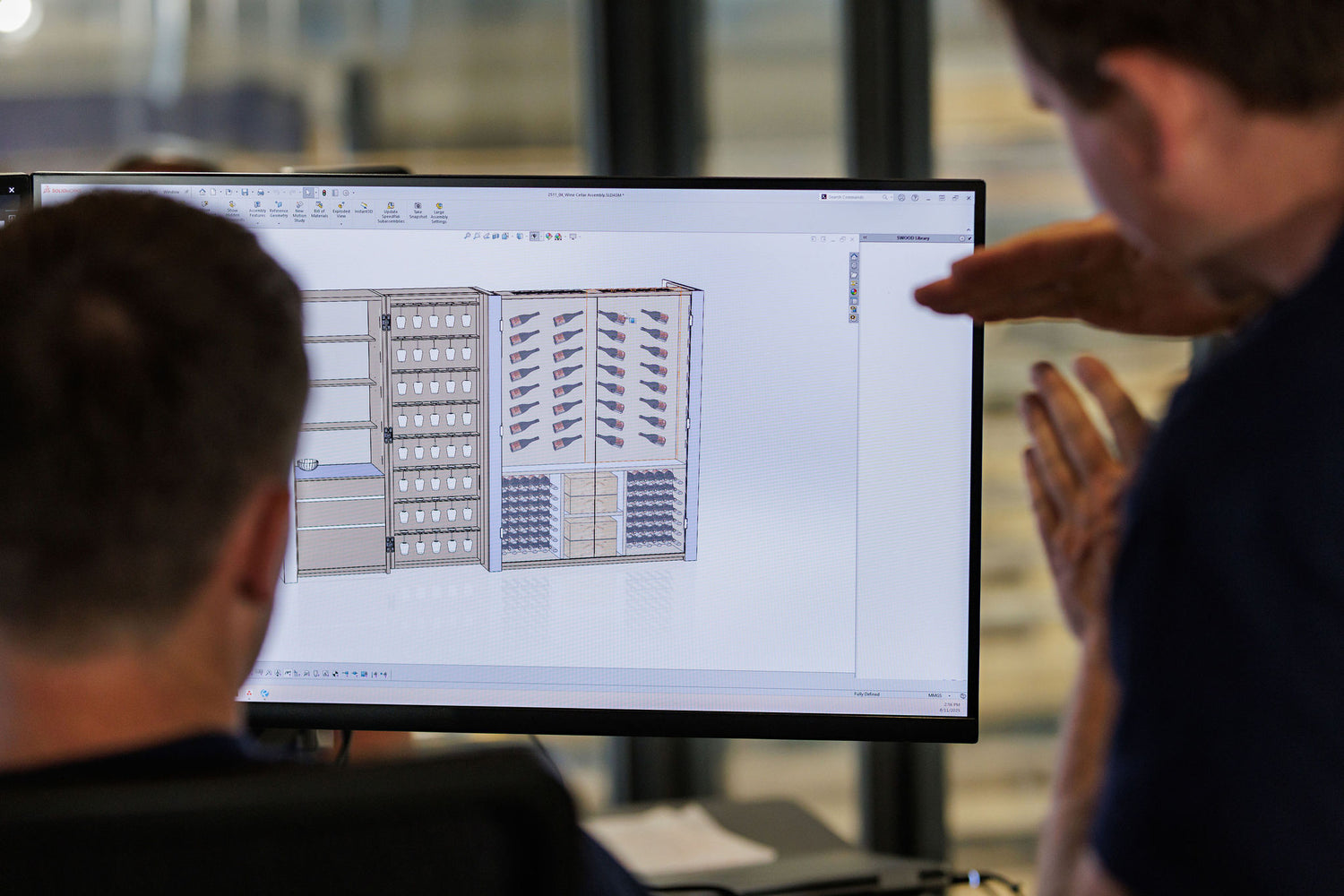 Two people looking at a computer screen displaying a technical diagram. BWP Spaces custom millwork in Kelowna, BC
