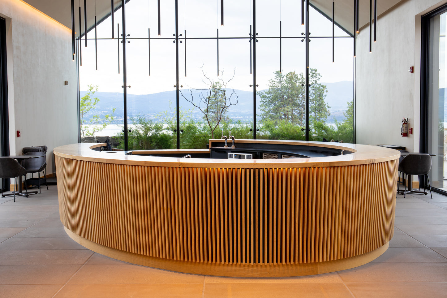 Interior of CedarCreek Estate Winery featuring custom oval tasting bar and retail shelving by BWP Spaces in collaboration with Erin Martin Design and Arcanum Architecture